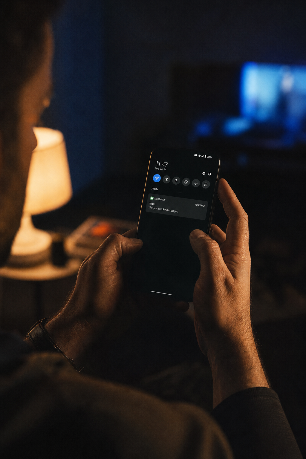 Man checking phone late at night, waiting for an income notification